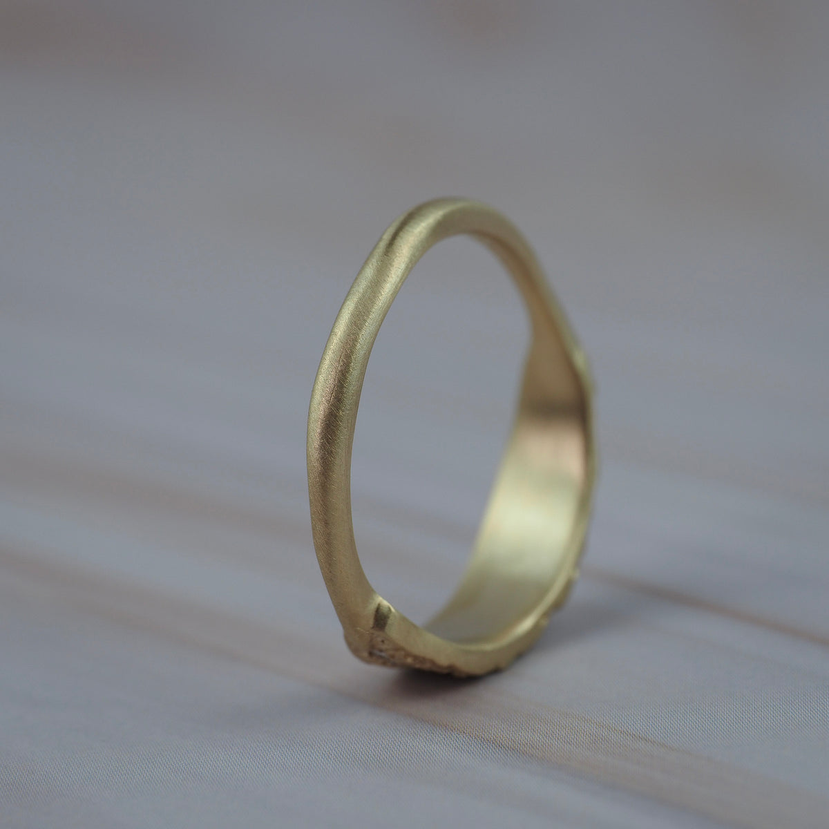 Back view of the organic textured leaf wedding band showing the hand carved gold setting and lab-grown diamonds.