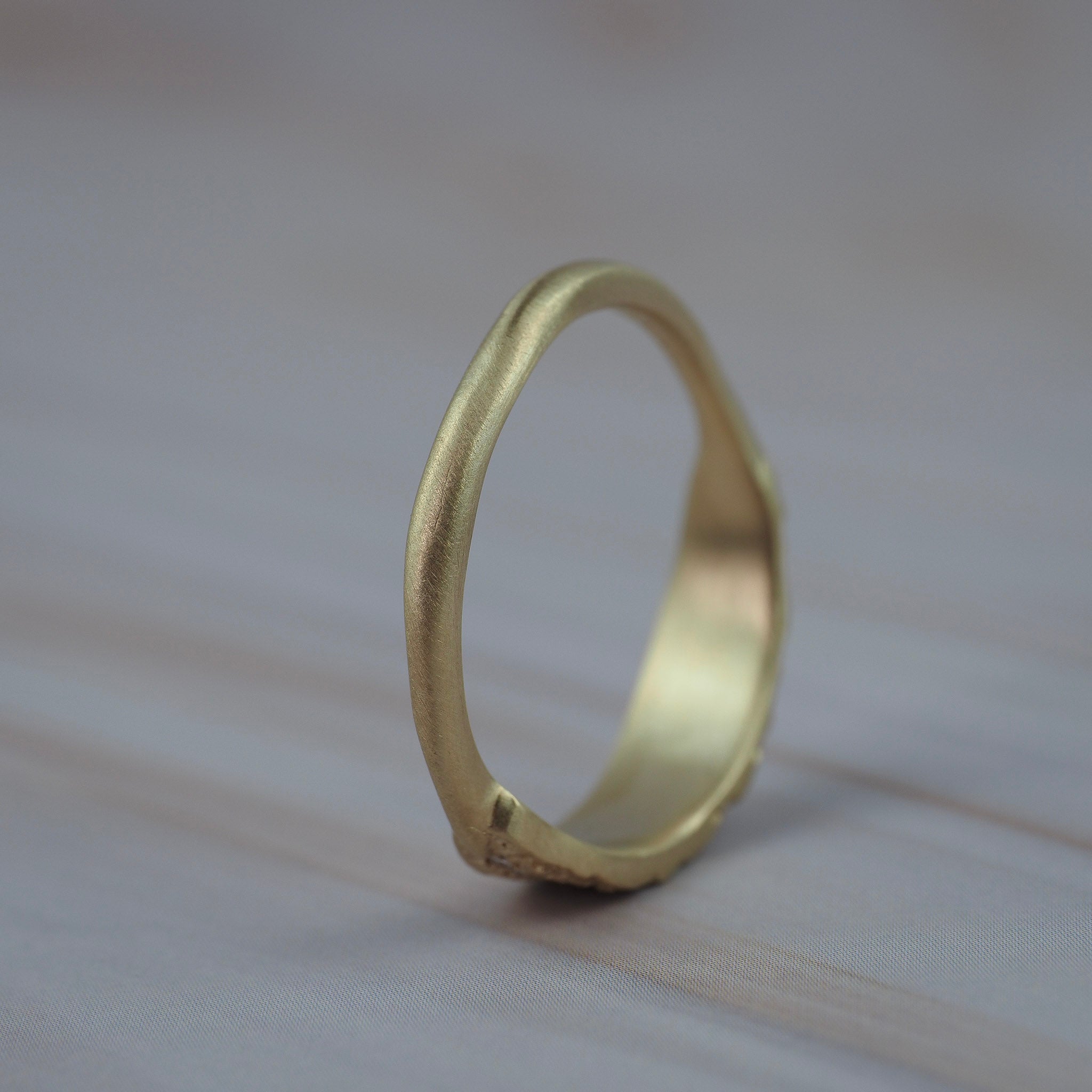 Back view of the organic textured leaf wedding band showing the hand carved gold setting and lab-grown diamonds.
