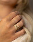 Stylized close-up of a model'd hand wearing organic pave diamond leaf rings.