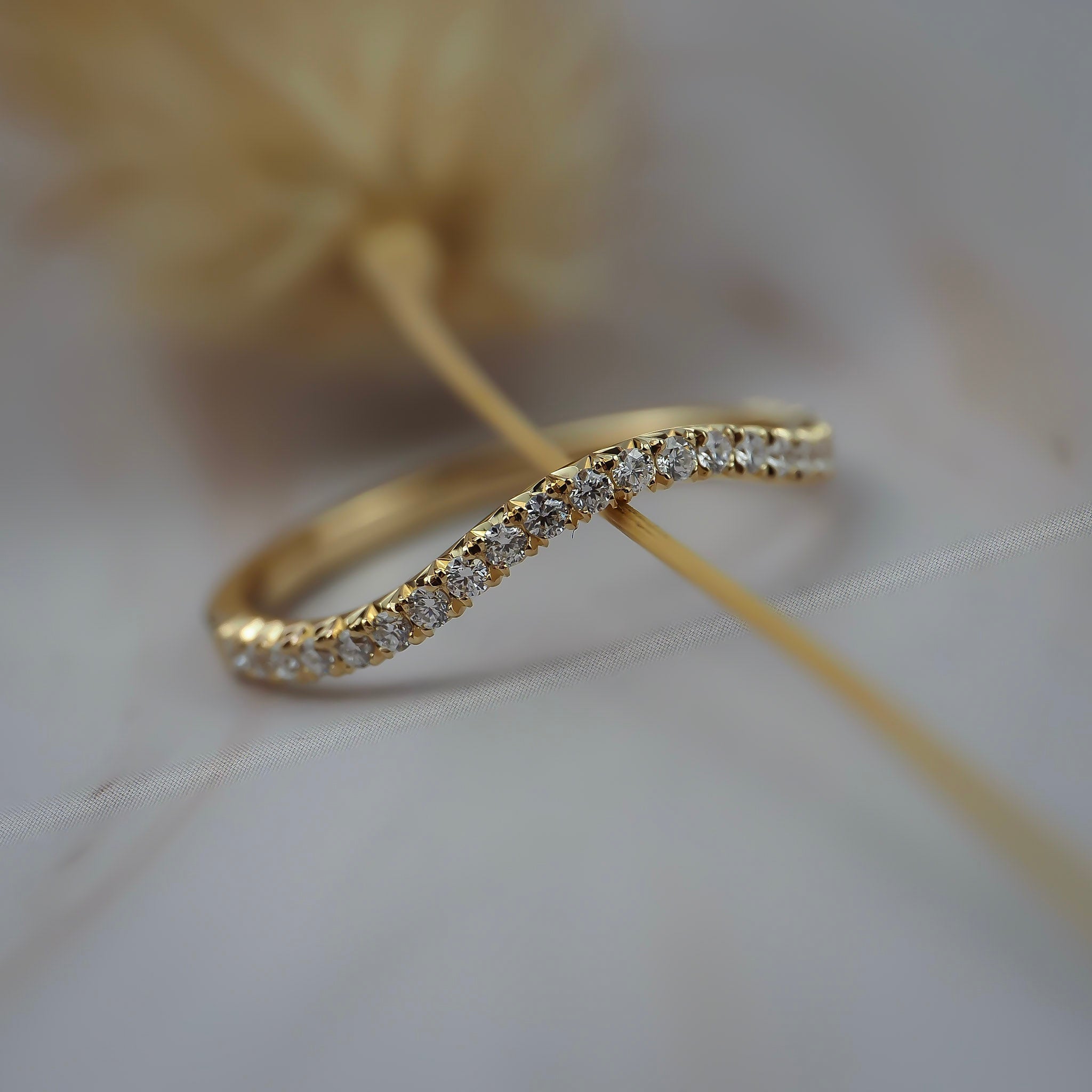 Pernelle curved French pave diamond wedding band featuring closet set Canadian diamonds in a delicate gold setting.