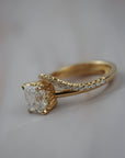Close-up of the Pernell curved French pave diamond weeding band paired with an asscher cut solitaire engagement ring. 