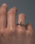 Close-up video of a woman wearing the Rebecca three stone engagement ring, featuring a champagne toned moval cut diamond and white full cut diamonds. 