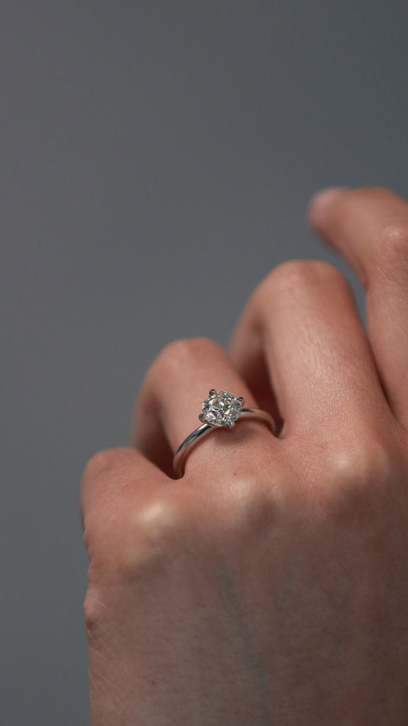 Close-up video of a women wearing the Myra compass platinum claw solitaire engagement ring with an Old European cut diamond.