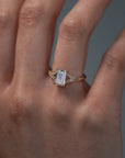 Close-up video of a woman wearing the Cora split-shank milgrain engagement solitaire with an emerald cut diamond and round accents. 