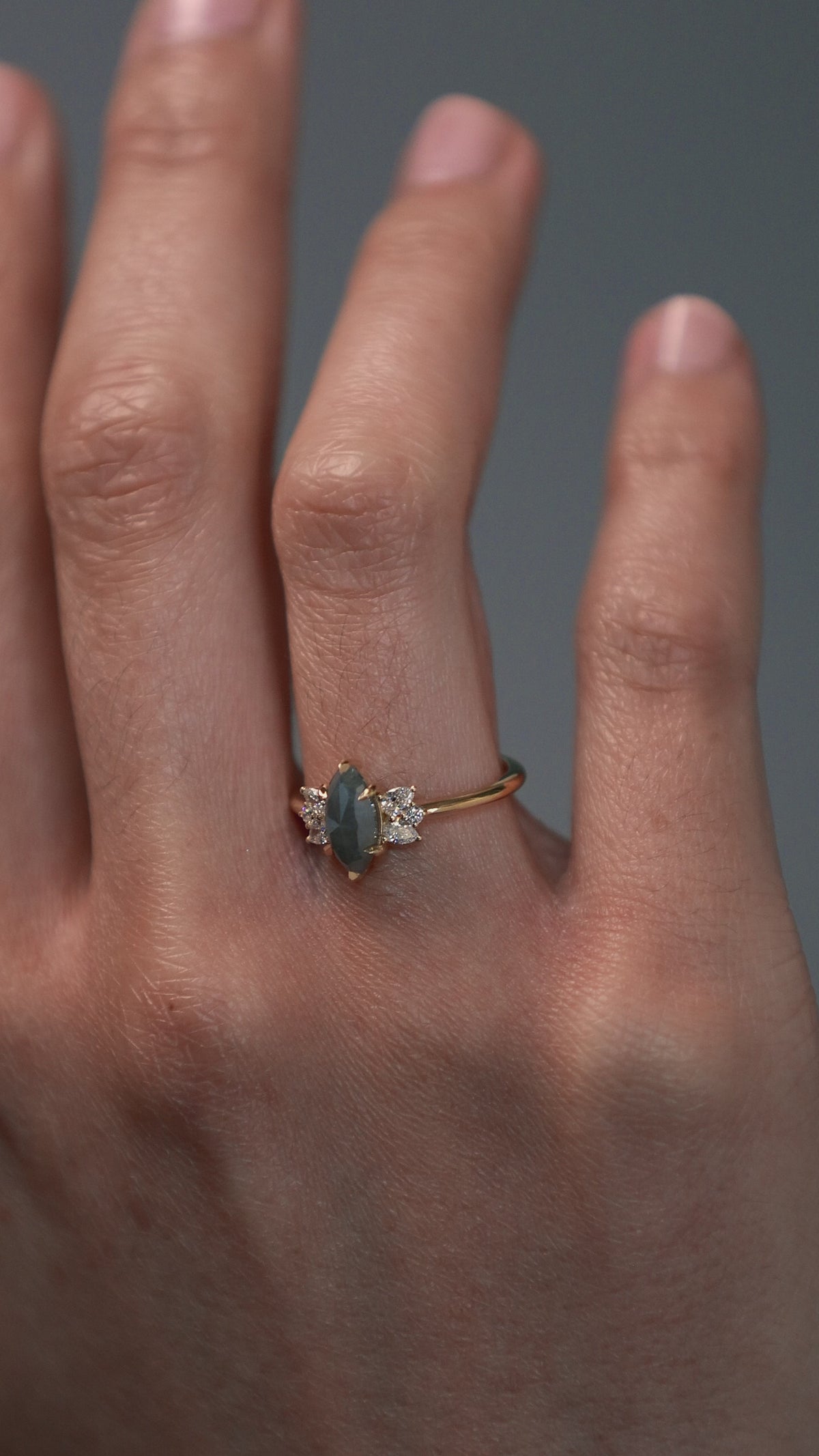 Close-up video of a woman wearing the Meghan salt and pepper marquise shaped rose cut cluster engagement ring on her hand.
