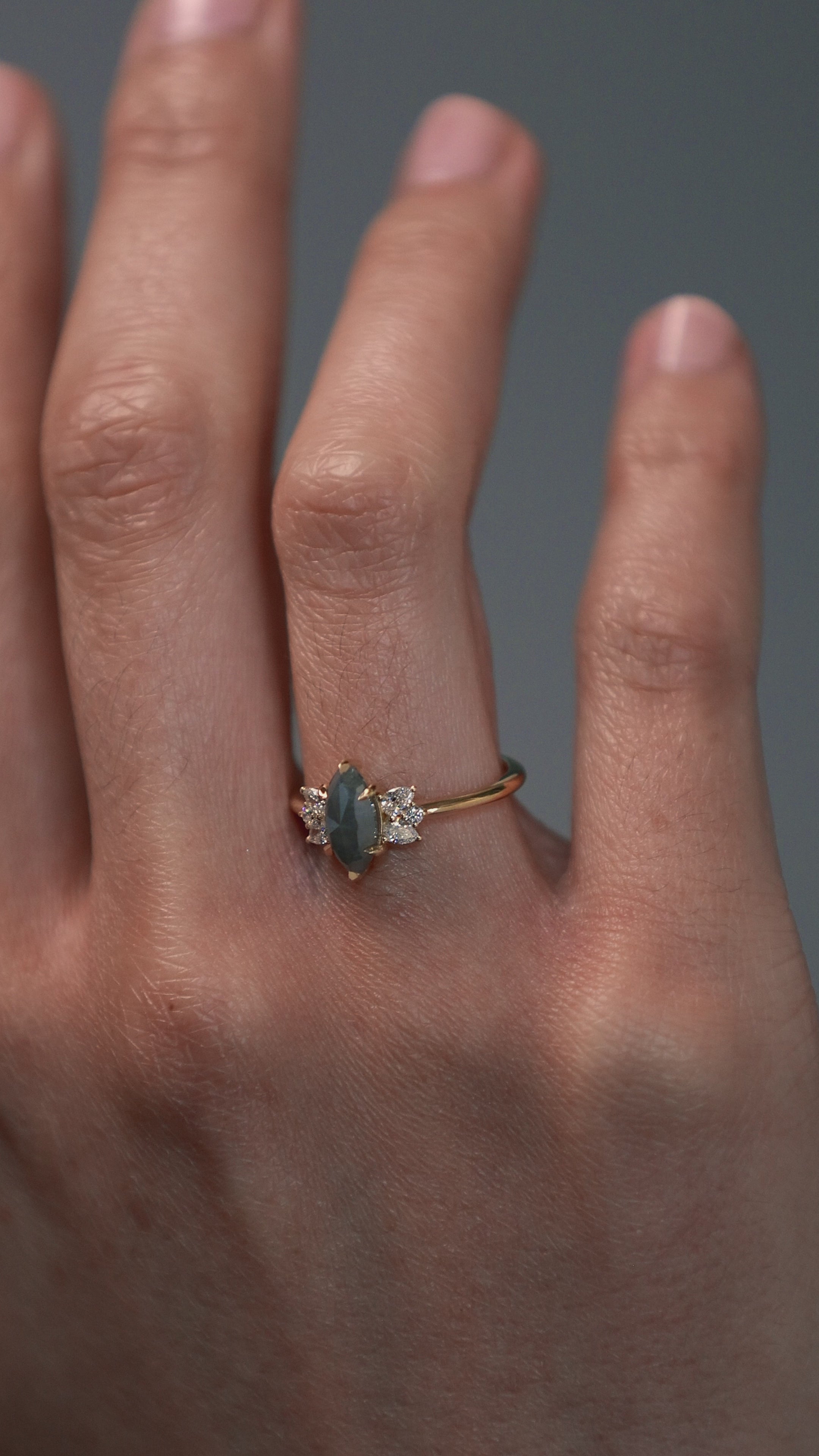 Close-up video of a woman wearing the Meghan salt and pepper marquise shaped rose cut cluster engagement ring on her hand.