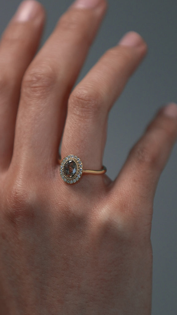 Close-up video of woman wearing the Air halo solitaire with a champagne toned Australian salt and pepper rose cut diamond surrounded by round Canadian diamonds. 