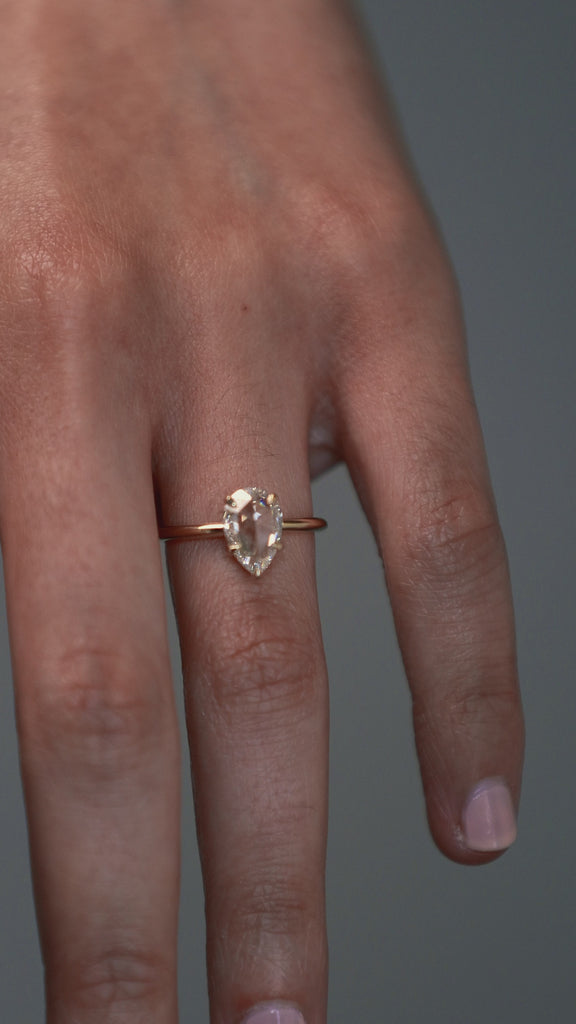 Close-up video of the Avery pear shaped rose cut diamond solitaire engagement ring worn n a woman's finger.