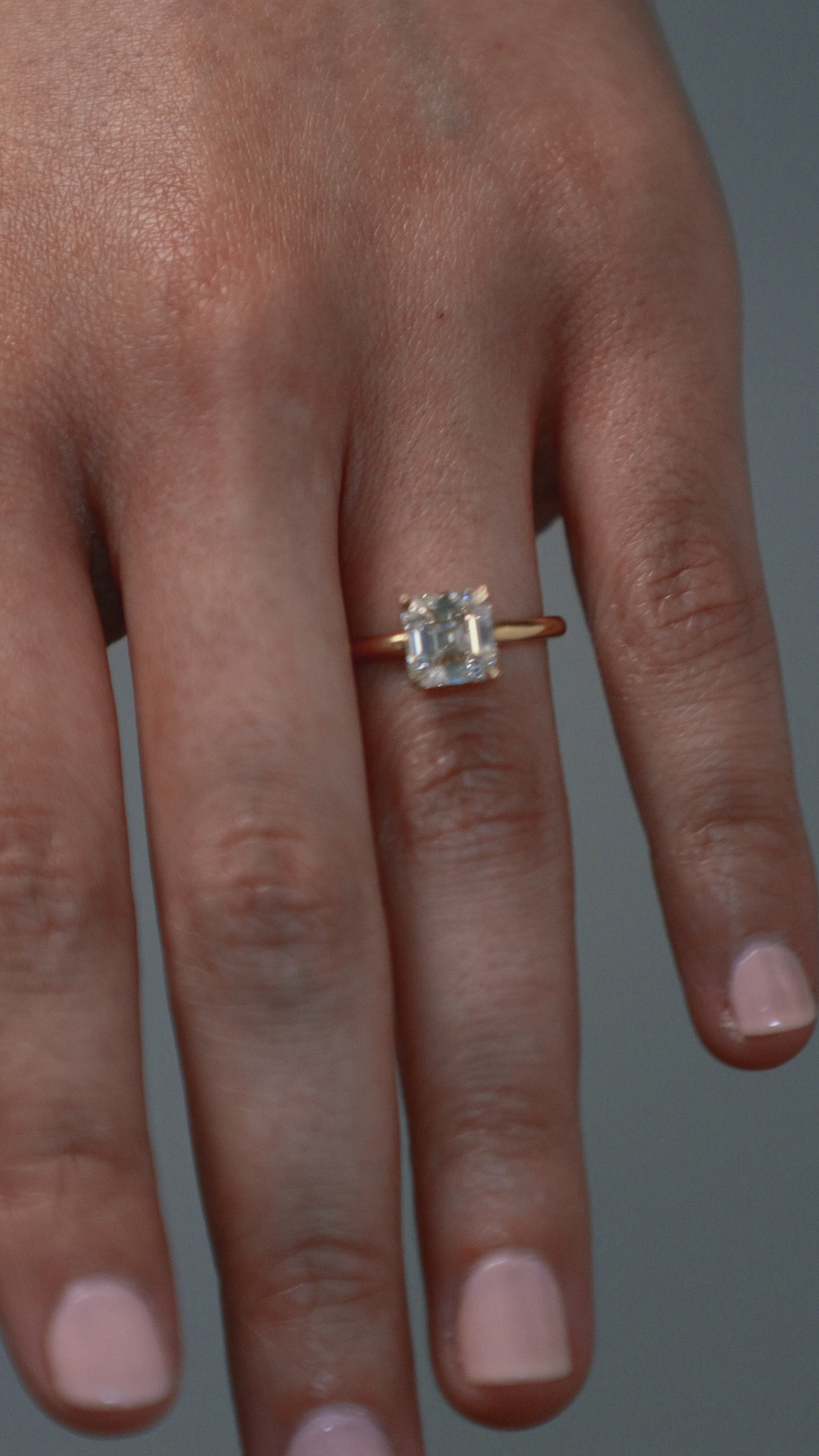 Close-up video of a woman wearing the Asscher cut diamond claw solitaire, showing the stones detail. 