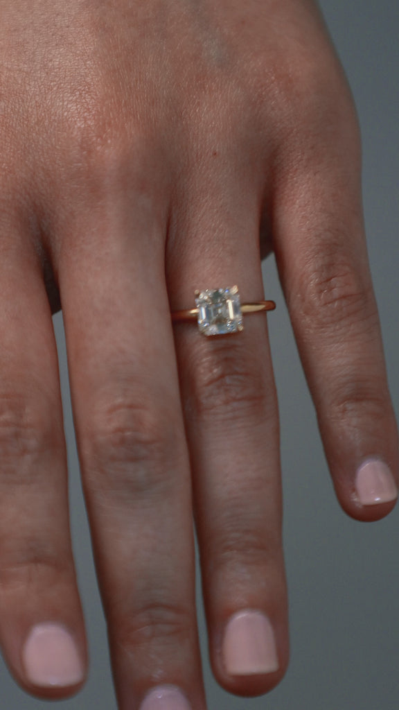 Close-up video of a woman wearing the Asscher cut diamond claw solitaire, showing the stones detail. 