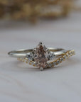 Rebecca three stone engagement ring paired with the Pernelle curved diamond pave wedding band, featuring a champagne toned moval cut diamond. 