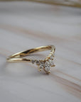 Side profile of the Trillium curved gold wedding band featuring marquise and round diamonds in a floral-inspired design.