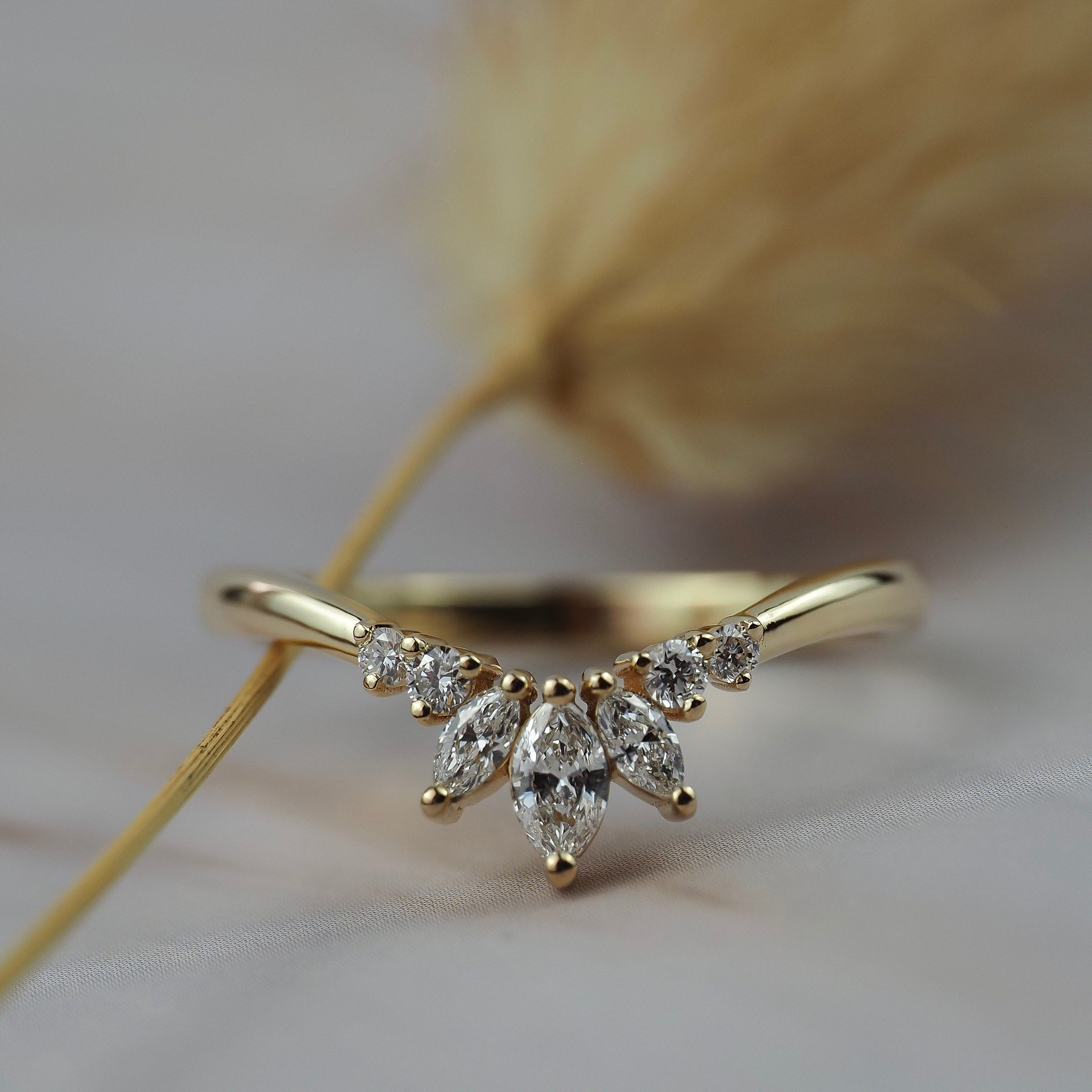 Trillium curved gold wedding band featuring marquise and round diamonds n a delicate floral inspired design.