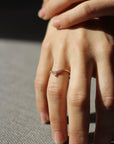 Close up of model hand wearing the Chevron Penelope womens wedding band by Fluid Jewellery in gold