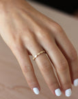 Close up of model hand wearing the Lotus womens wedding band by Fluid Jewellery in gold