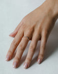 Close up of modle hand wearing the curved Ida womens wedding band by Fluid Jewellery in gold