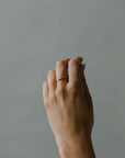 Close up of model hand wearing the curved Ida womens wedding band by Fluid Jewellery in gold