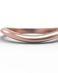Close up of the curved flow womens wedding band by Fluid Jewellery in rose gold