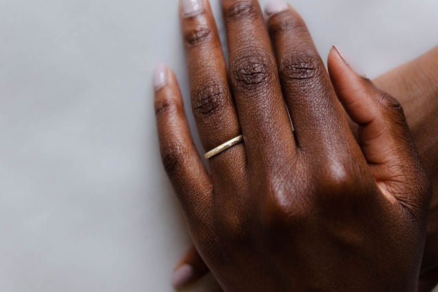 Close up of model hand wearing the Starlight womens wedding band by Fluid Jewellery in gold